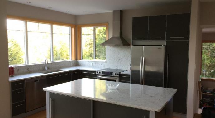 medium grey kitchen cabinets with silver frames natural stone countertops