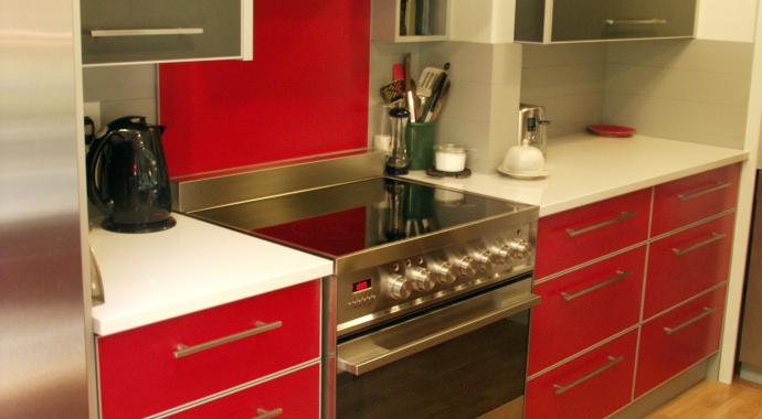 Cuisine en aluminium rouge vif avec des touches constrastées  gris foncé et argentées