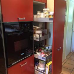 cocina aluminio en rojo ladrillo con muebles altos con puertas blancas y con cristal