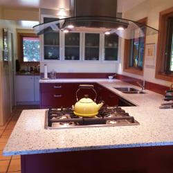 cocina aluminio en rojo ladrillo con muebles altos con puertas blancas y con cristal