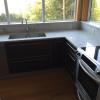 medium grey kitchen cabinets with silver frames natural stone countertops